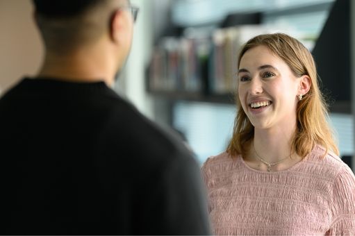 young adult male and female smiling and talking