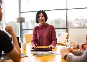 aini at desk with colleagues