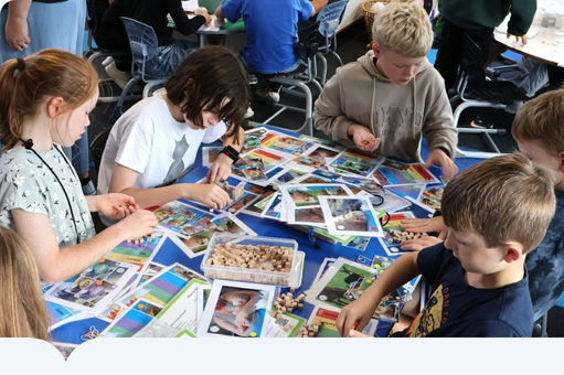 House of science - kids looking at cards on a school table